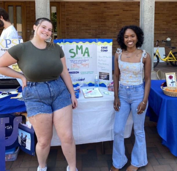 students standing in front of a table at the info fair