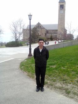 Zhe Goerge Zhang standing in front of a building at Cornell
