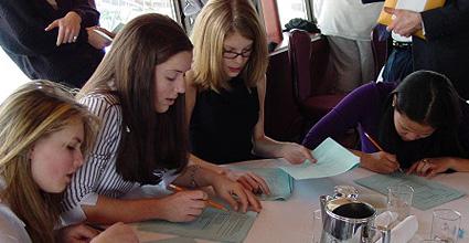 Four students working together on a packet of worksheets