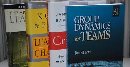 A group of textbooks, the front textbook is "Group Dynamics for Teams" by Daniel Levi