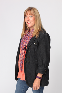 Diane Brearley in a peach blouse and scarf, with a black denim jacket