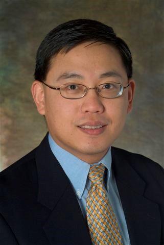 Dr. Yong-Pin Zhou in a black business suit and light blue shirt
