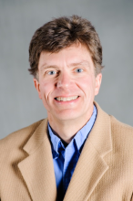Dr. Mark Springer in tan jacket and blue shirt