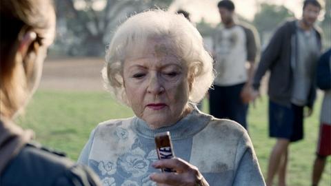Betty White looking at a snickers bar