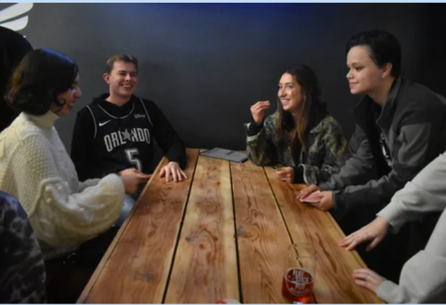 Group of students gathered around a table at Flatstick Pub